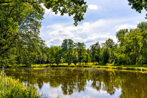 Historic park surrounding XVI century Rozalin Palace with vintage trees and ponds during summer season in Rozalin village in Mazovia region of Poland photo