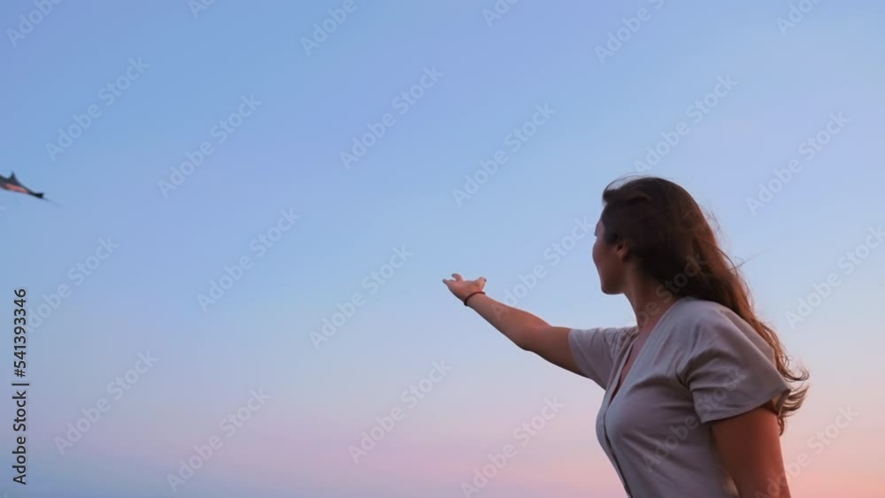 Control your life metaphor. Girl at sunset leading flying kite with magic hand. Predicting future. Secret knowledge understanding world. Peaceful scene with person piloting kite. Film grain texture. Control your life metaphor. Girl at sunset leading flying kite with magic hand. Predicting future. Secret knowledge understanding world. Peaceful scene with person piloting kite. Film grain texture.