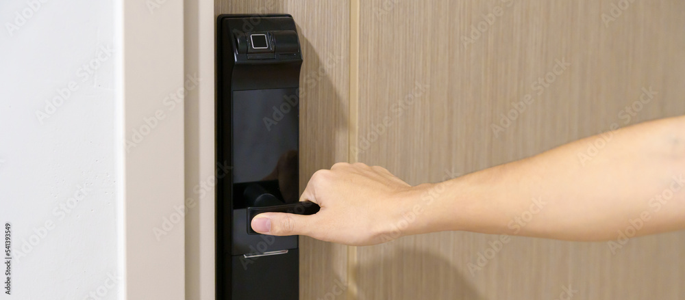 man holding handle of smart digital door lock while open or close the door. Technology, electrical and lifestyle concepts