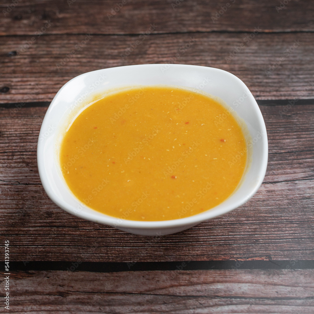 pumpkin soup in a bowl on wooden table pumpkin soup in a bowl on wooden table