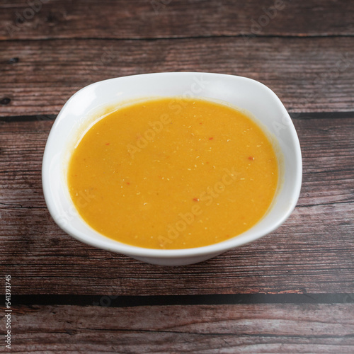 pumpkin soup in a bowl on wooden table