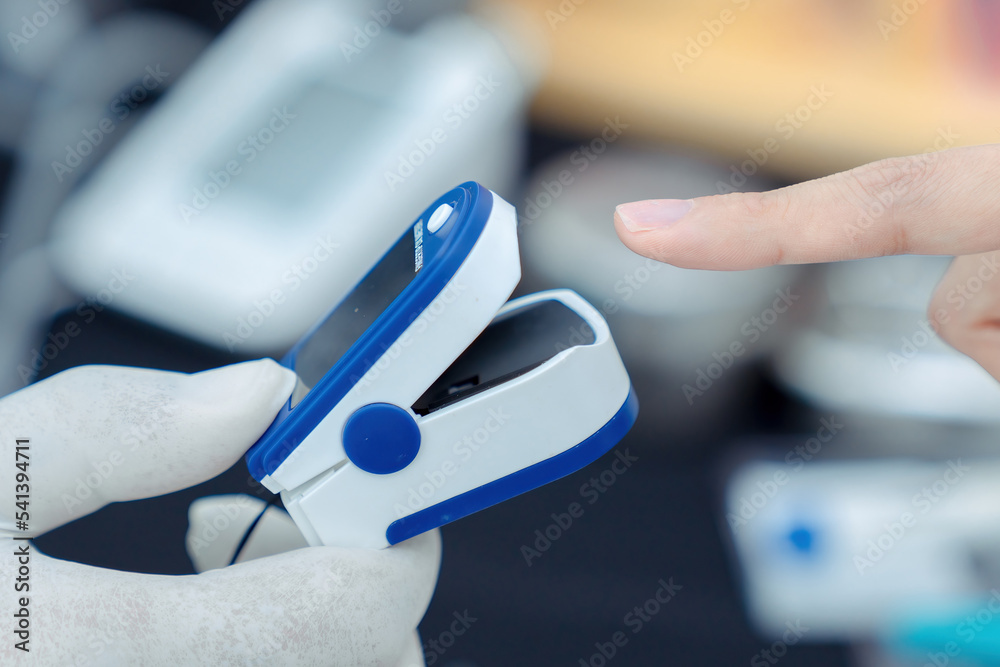 Doctor checking oxygenation with fingertip pulse oximeter. Saturation blood of oxygen. Measuring the patient's blood saturation with an oximeter Doctor checking oxygenation with fingertip pulse oximeter. Saturation blood of oxygen. Measuring the patient's blood saturation with an oximeter