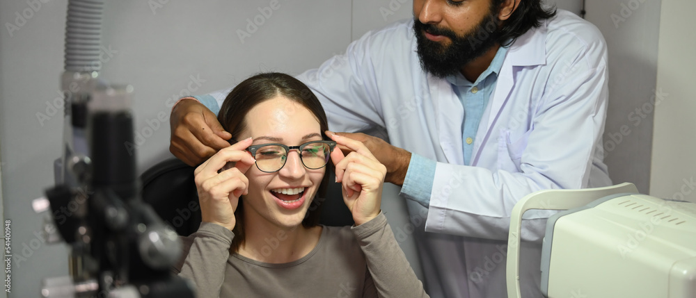Indian male ophthalmologist is helping patient choosing the most appropriate eyeglasses. Eyesight and vision concept Indian male ophthalmologist is helping patient choosing the most appropriate eyeglasses. Eyesight and vision concept