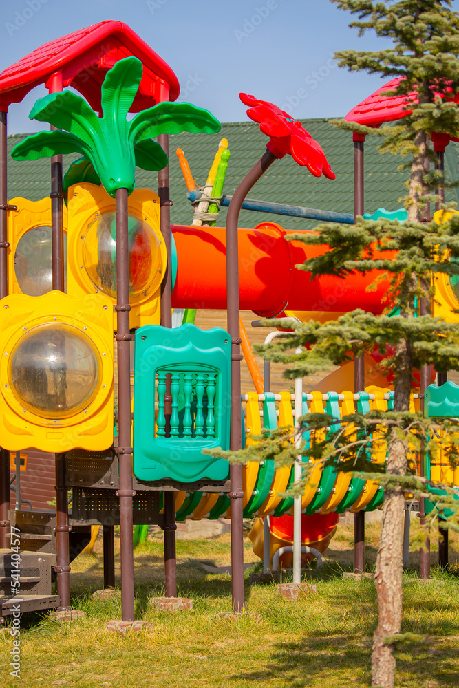 Bright playground in the park. Playground with slides and swings for children.