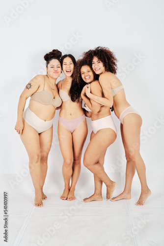 Cheerful diverse friends in underwear standing together