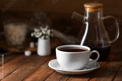 Cup with delicious tea on wooden table, space for text