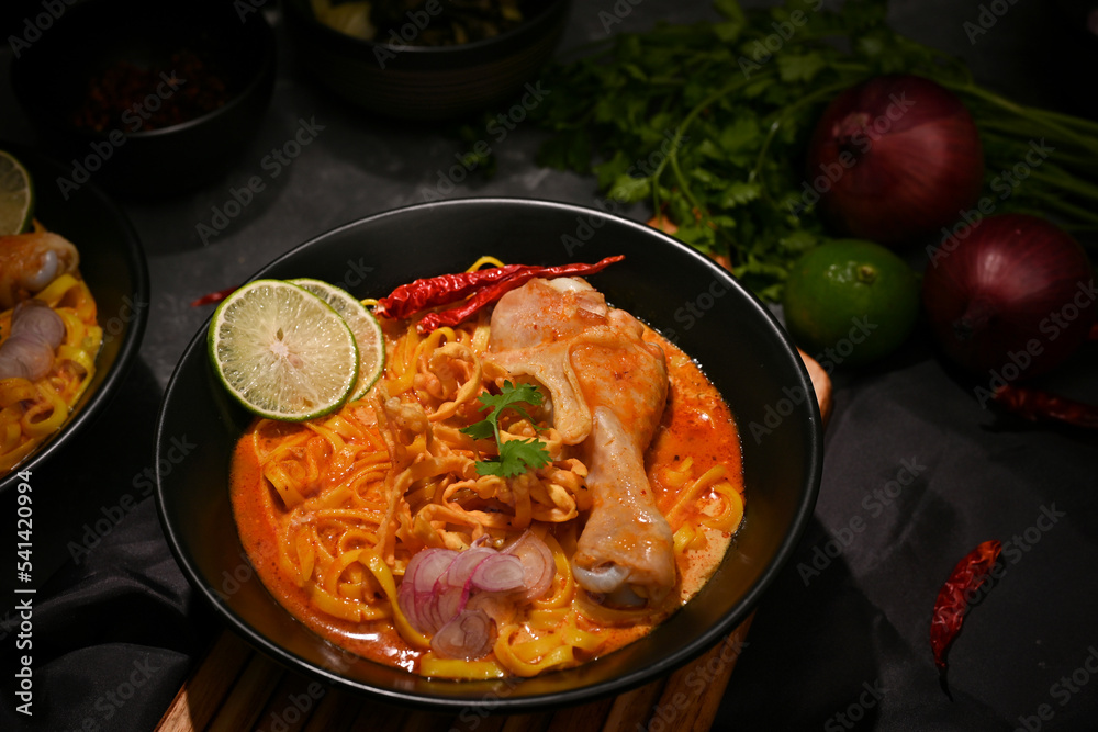Delicious Khao Soi Kai or Thai curry noodles with chicken drumstick, vegetables