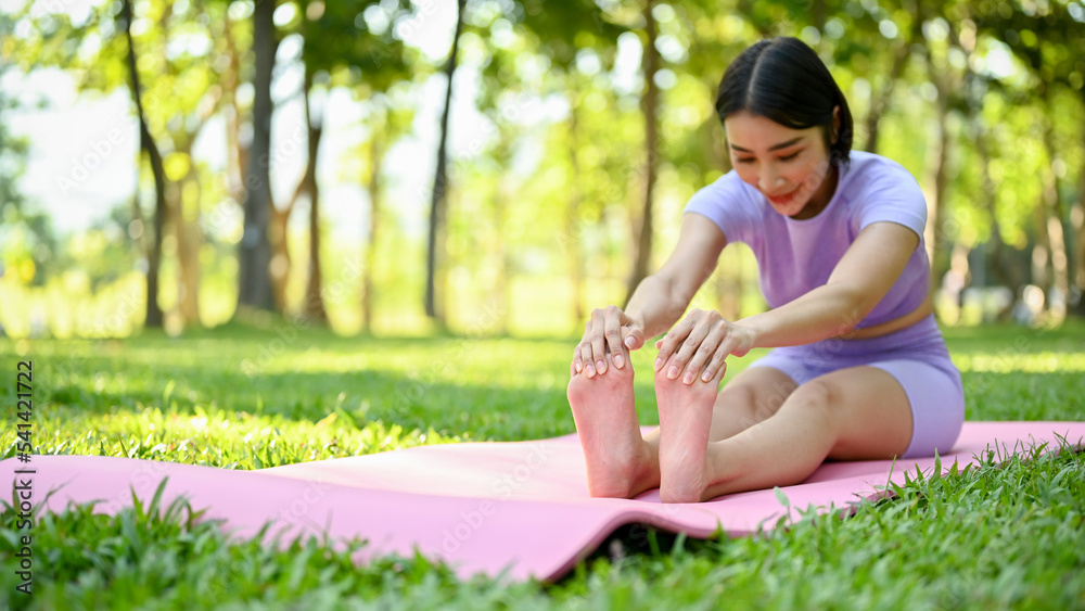 Healthy Asian woman in sportswear stretching her legs and arms on yoga mat Healthy Asian woman in sportswear stretching her legs and arms on yoga mat