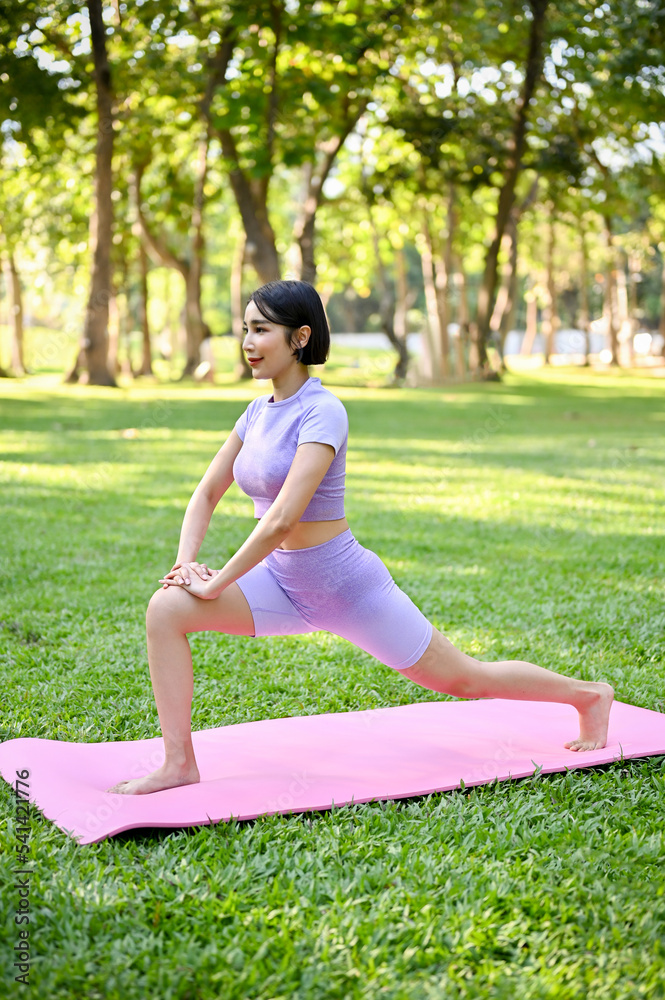 Attractive Asian woman stretching her legs, warm up before workout, practicing yoga Attractive Asian woman stretching her legs, warm up before workout, practicing yoga