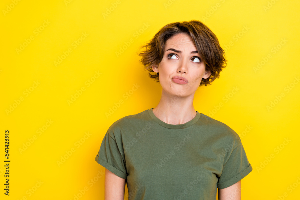 Photo of gorgeous doubtful suspicious girl with bob hairstyle wear khaki t-shirt look empty space isolated on yellow color background Photo of gorgeous doubtful suspicious girl with bob hairstyle wear khaki t-shirt look empty space isolated on yellow color background