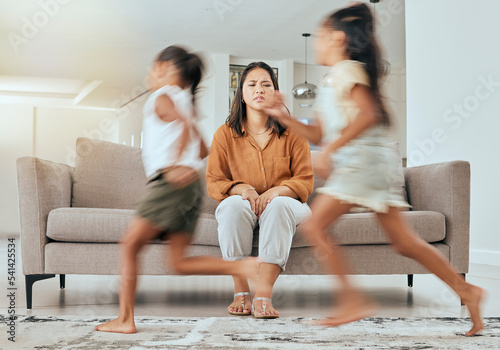 Child care stress, mother and children running with energy with mom feeling anxiety on a home sofa. Mama burnout, kids and fast siblings run in the living room lounge with tired mom on the couch
