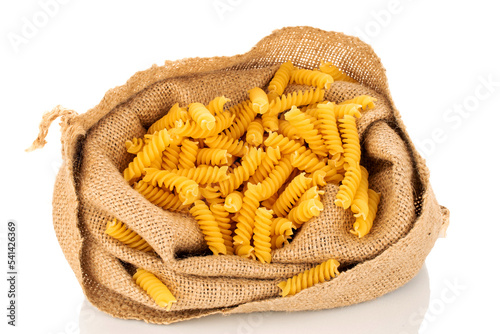 Durum wheat pasta in a jute bag, macro, isolated on white background.