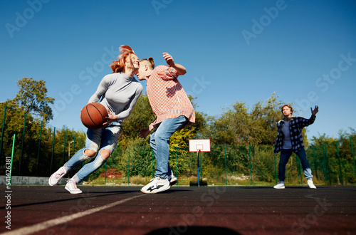 Group of teens, students playing street basketball at basketball court outdoors. Sport, leisure activities, hobbies, team, friendship