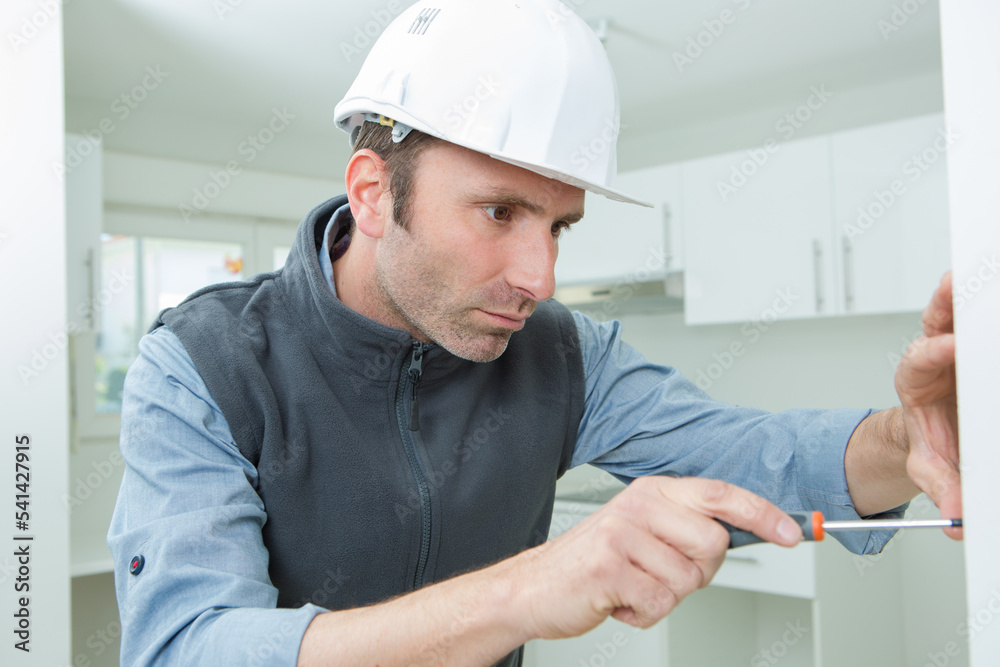 middle-aged man assembling a shelving at home middle-aged man assembling a shelving at home