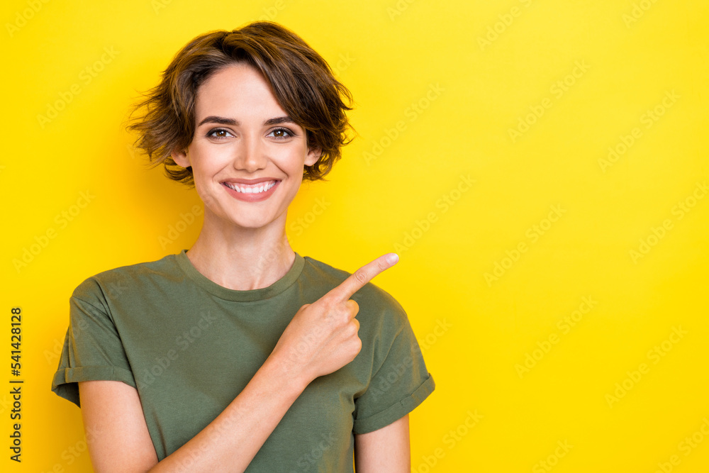Photo of satisfied optimistic nice girl with bob hairstyle wear khaki t-shirt indicating empty space isolated on yellow color background Photo of satisfied optimistic nice girl with bob hairstyle wear khaki t-shirt indicating empty space isolated on yellow color background