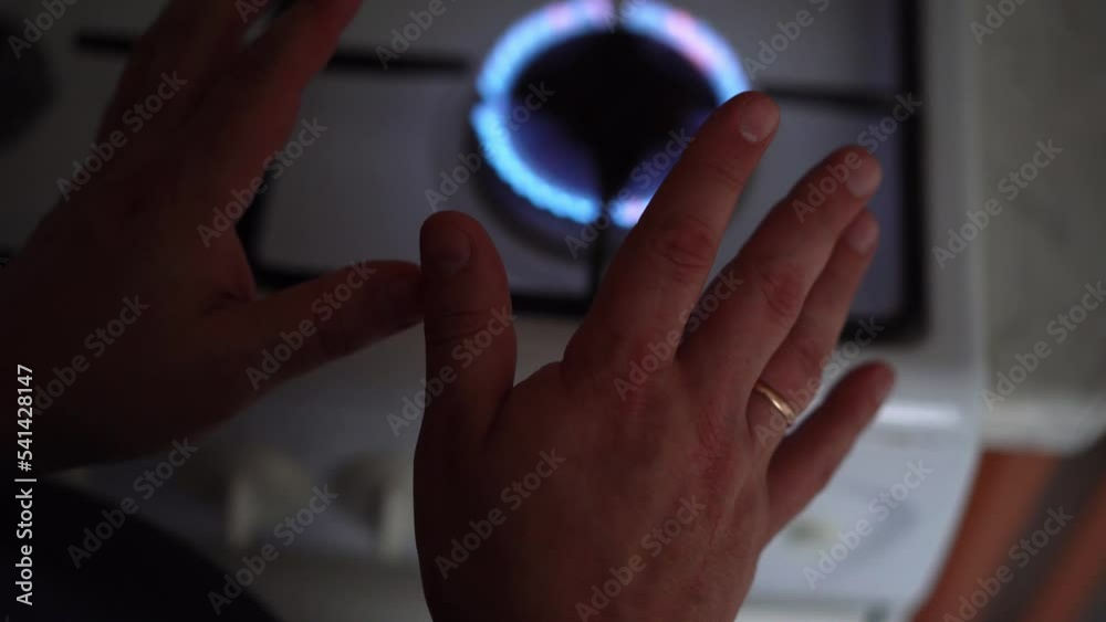 Man holding his hands over burning fire. Room heating, natural gas burn on stove Man holding his hands over burning fire. Room heating, natural gas burn on stove