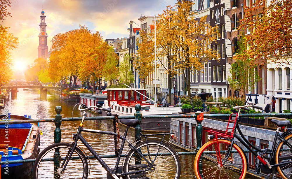 Bike over canal Amsterdam city autumn yellow leaf fall. Picturesque town landscape in Netherlands with view on river Amstel.