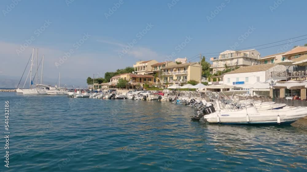 Panning shot of the harbour in Kassiopi, with a boat coming in to dock Panning shot of the harbour in Kassiopi, with a boat coming in to dock