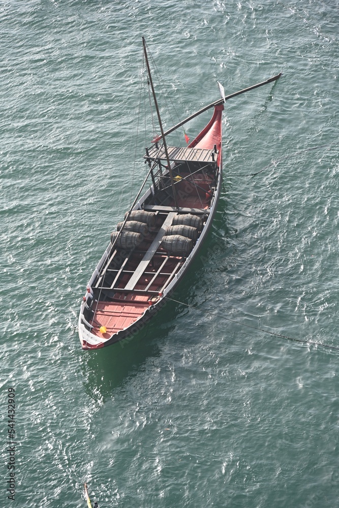Fototapeta premium A boat carries wine on Douro river in Oporto, Portugal