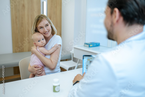 Cheerful mother and her newborn child in the pediatrician office