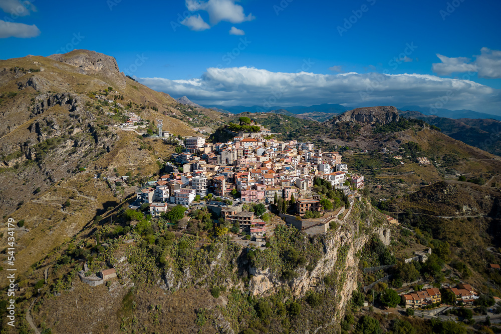 Aerial view of the mountains and a small village on top of Castelmola. Sunny morning. Sicily. Italy