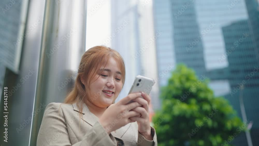 Happy businesswoman smile face chatting on smartphone on street at city center Happy businesswoman smile face chatting on smartphone on street at city center