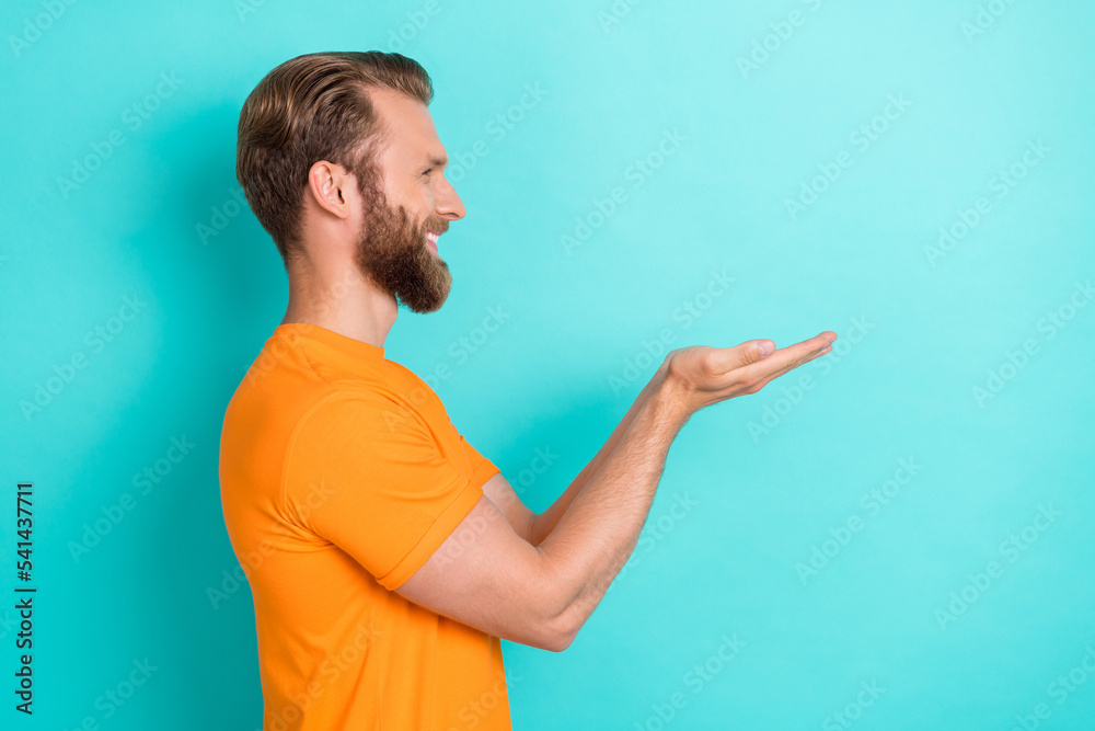 Profile photo of funky beard guy hold empty space wear orange t-shirt isolated on teal color backgroiund Profile photo of funky beard guy hold empty space wear orange t-shirt isolated on teal color backgroiund