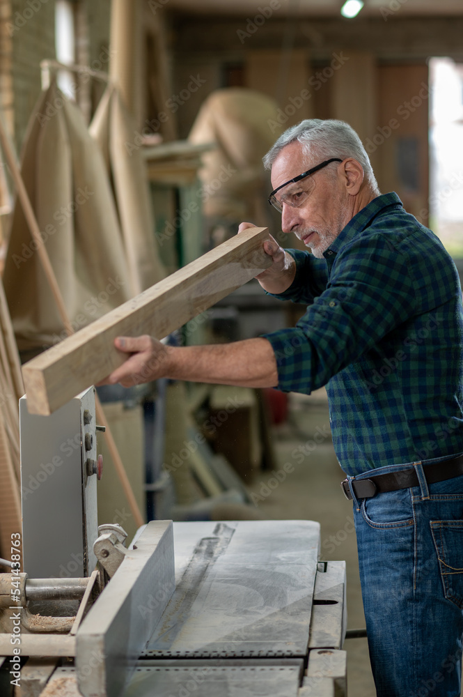 Carpenter working with wood in a workshop Carpenter working with wood in a workshop