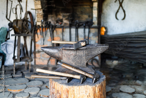 Old anvil with iron hammers in a vintage forge.