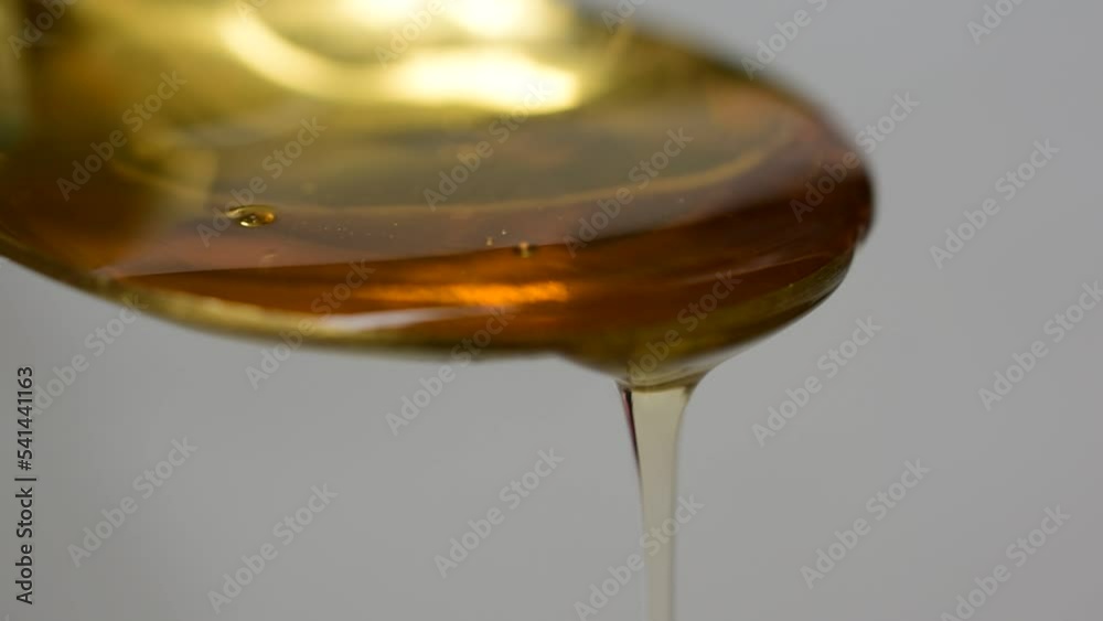 honey dripping from a spoon honey dripping from a spoon