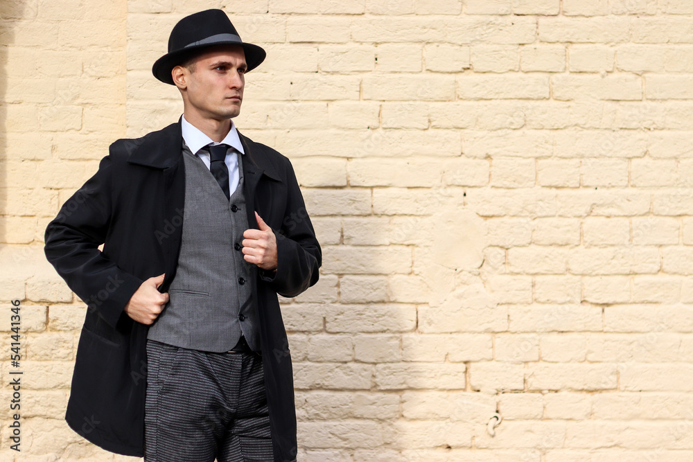 Men's photo shoot in a classic plaid suit and hat against a brick wall. Men's photo shoot in a classic plaid suit and hat against a brick wall.