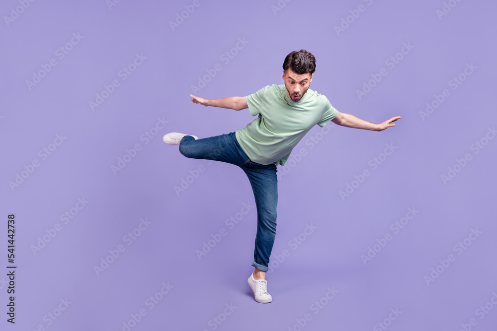 Full length photo of astonished terrified man stand one leg foot top mountain look down empty space isolated on purple color background