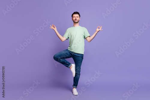 Fototapeta Naklejka Na Ścianę i Meble -  Full length photo of concentrated positive man wear denim stand one foot leg enjoy hobby time isolated on purple color background