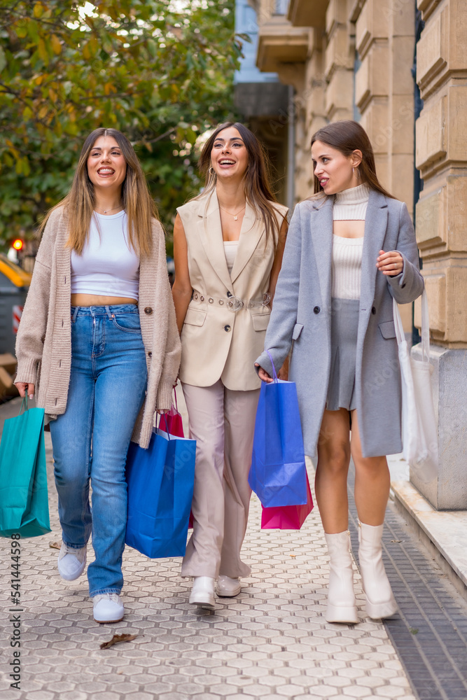 Fototapeta premium Women shopping friends having fun, offers from city stores with paper bags, hobbies