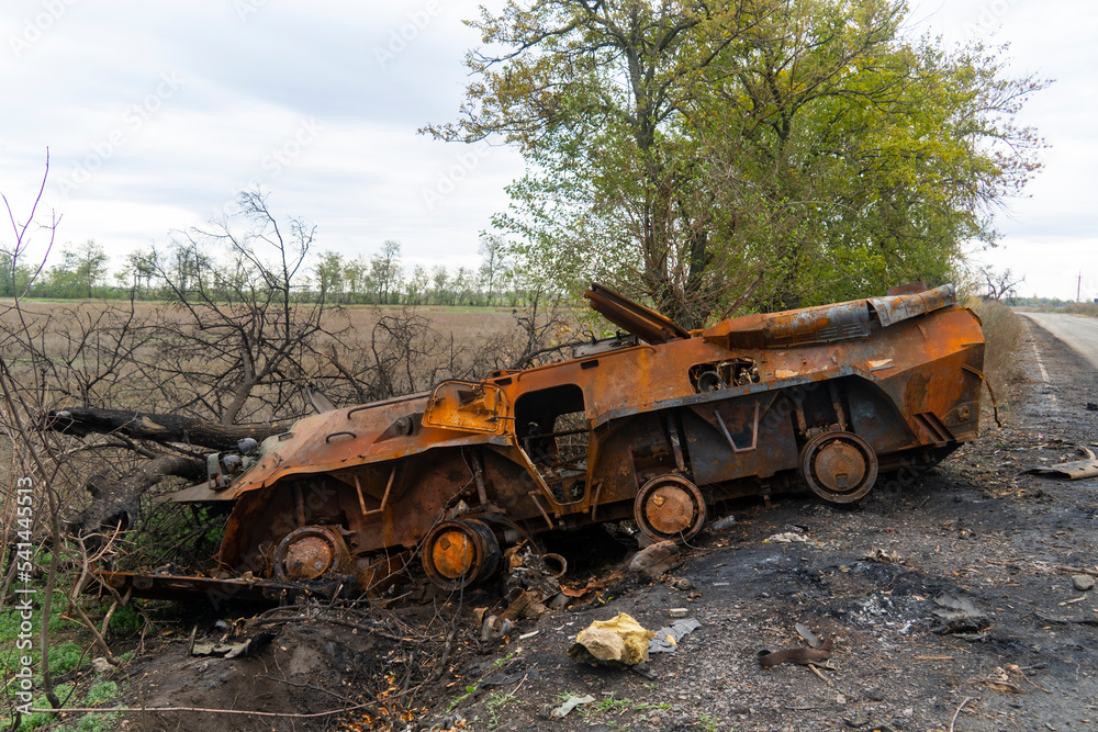 Obraz premium War in Ukraine. 2022 Russian invasion of Ukraine. Countryside. After the battle. Destroyed burnt combat vehicle stands on the side of the road