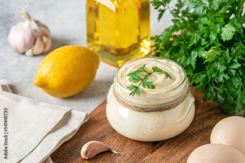 Photos Aioli sauce with ingredients on a wooden cutting board