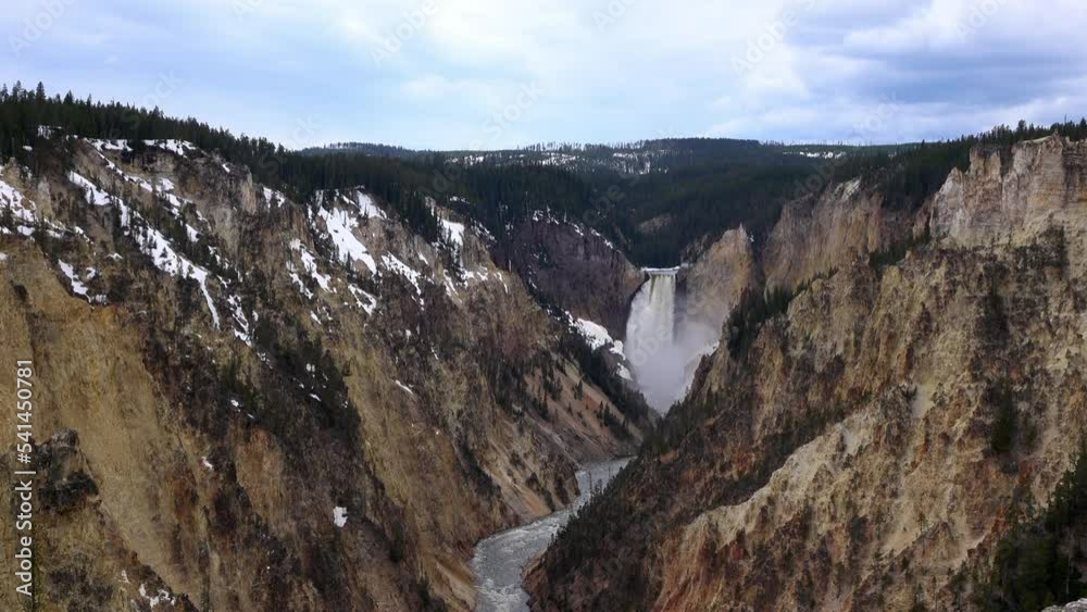 Aerial Lockdown Shot Of Waterfall Flowing In River Amidst Mountains Under Cloudy Sky - Yellowstone Park, Montana Aerial Lockdown Shot Of Waterfall Flowing In River Amidst Mountains Under Cloudy Sky - Yellowstone Park, Montana