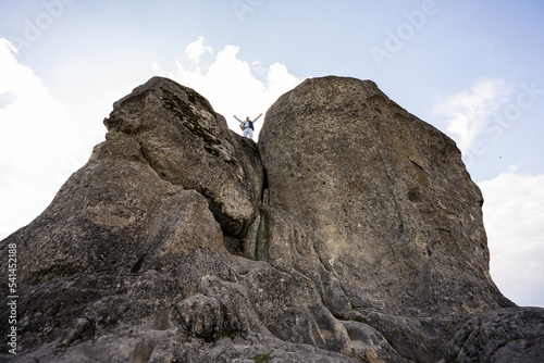 Man climbing on top of big stone in hill. Pidkamin, Ukraine. © AS Photo Family