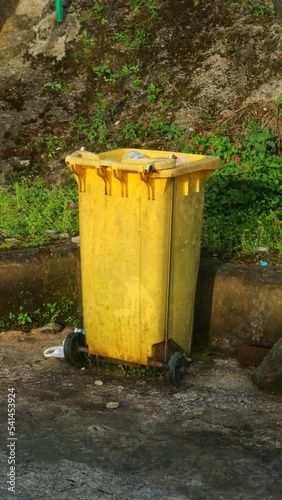 yellow trash can in a tourist place