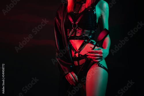 woman with a sexy body in beautiful underwear holds a leather flogger whip in her hand for BDSM sex with domination and submission