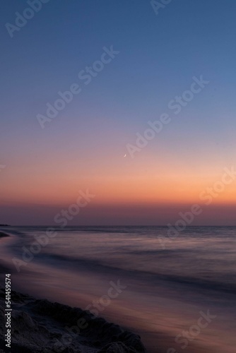 Vertical and long exposure shot of the sea and mountains on a beautiful sunset