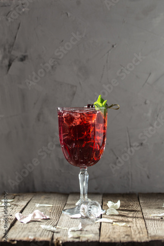 Berry alcoholic cocktail liqueur, vodka, ice and mint Refreshing drink on wooden table