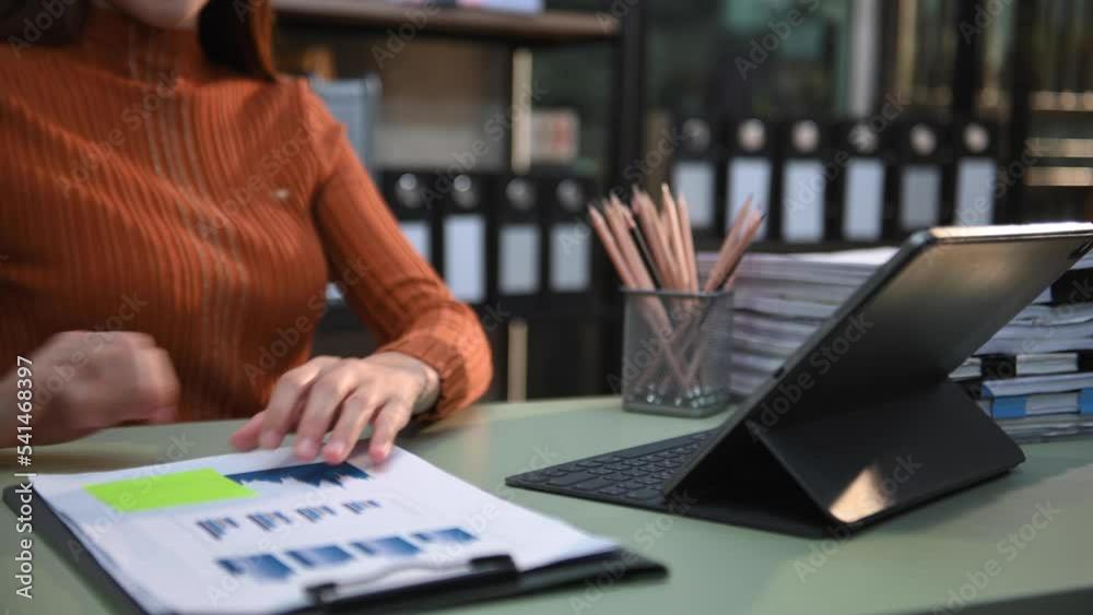 Confident businesswoman working on laptop and tablet at her workplace at modern office.. Confident businesswoman working on laptop and tablet at her workplace at modern office..