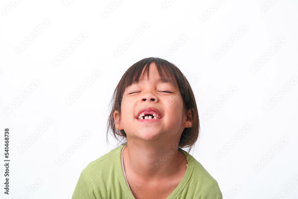 Portrait of an Asian girl with broken upper baby teeth and first permanent teeth. Friendly little girl showing her broken teeth isolated on white background. Portrait of an Asian girl with broken upper baby teeth and first permanent teeth. Friendly little girl showing her broken teeth isolated on white background.
