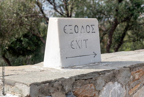 stone with the inscription "exit" in Greek and English