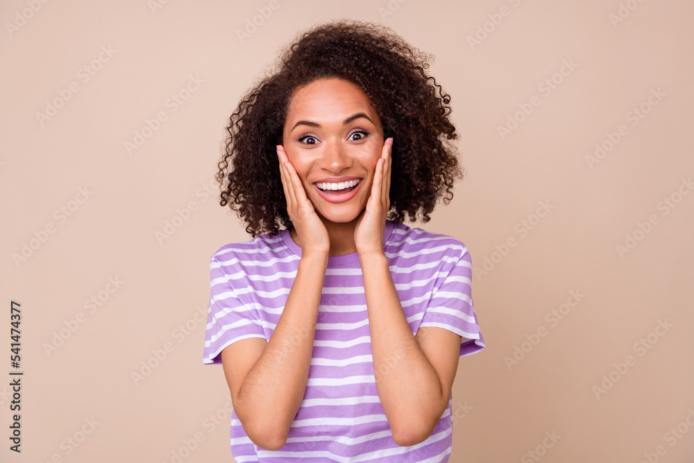 Photo of young attractive nice girl wear striped t-shirt shocked surprised touch cheek toothy smile shopping sale isolated on beige color background Photo of young attractive nice girl wear striped t-shirt shocked surprised touch cheek toothy smile shopping sale isolated on beige color background