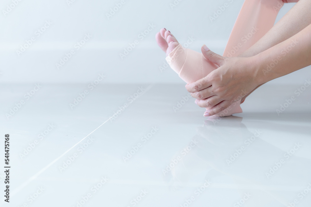 custom made wallpaper toronto digitalWoman holding her leg with sprained ankle and elastic bandage isolated on white background. ankle bandage