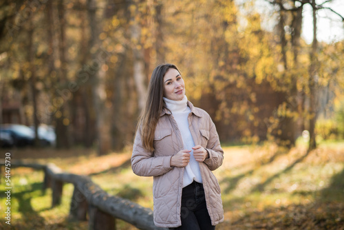brunette in a yellow jacket on the background of autumn nature. Young woman in a gray jacket, Portrait of a woman in autumn, warm autumn concept