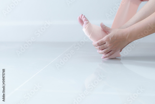 Wallpaper Mural Woman holding her leg with sprained ankle and elastic bandage isolated on white background. ankle bandage Torontodigital.ca