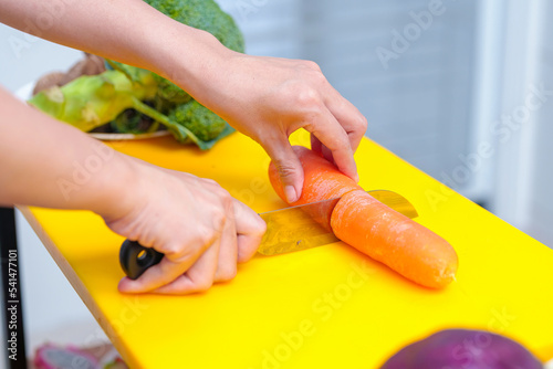 Young woman cooking romantic dinner at home cutting vegetables close-up ,Closeup of human hands cooking vegetables salad in kitchen on the glass table with reflection
